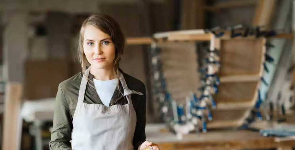 Jeune femme artisan en tablier de travail